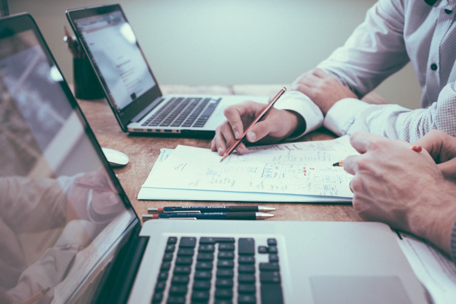 Two colleagues working through figures together at a desk